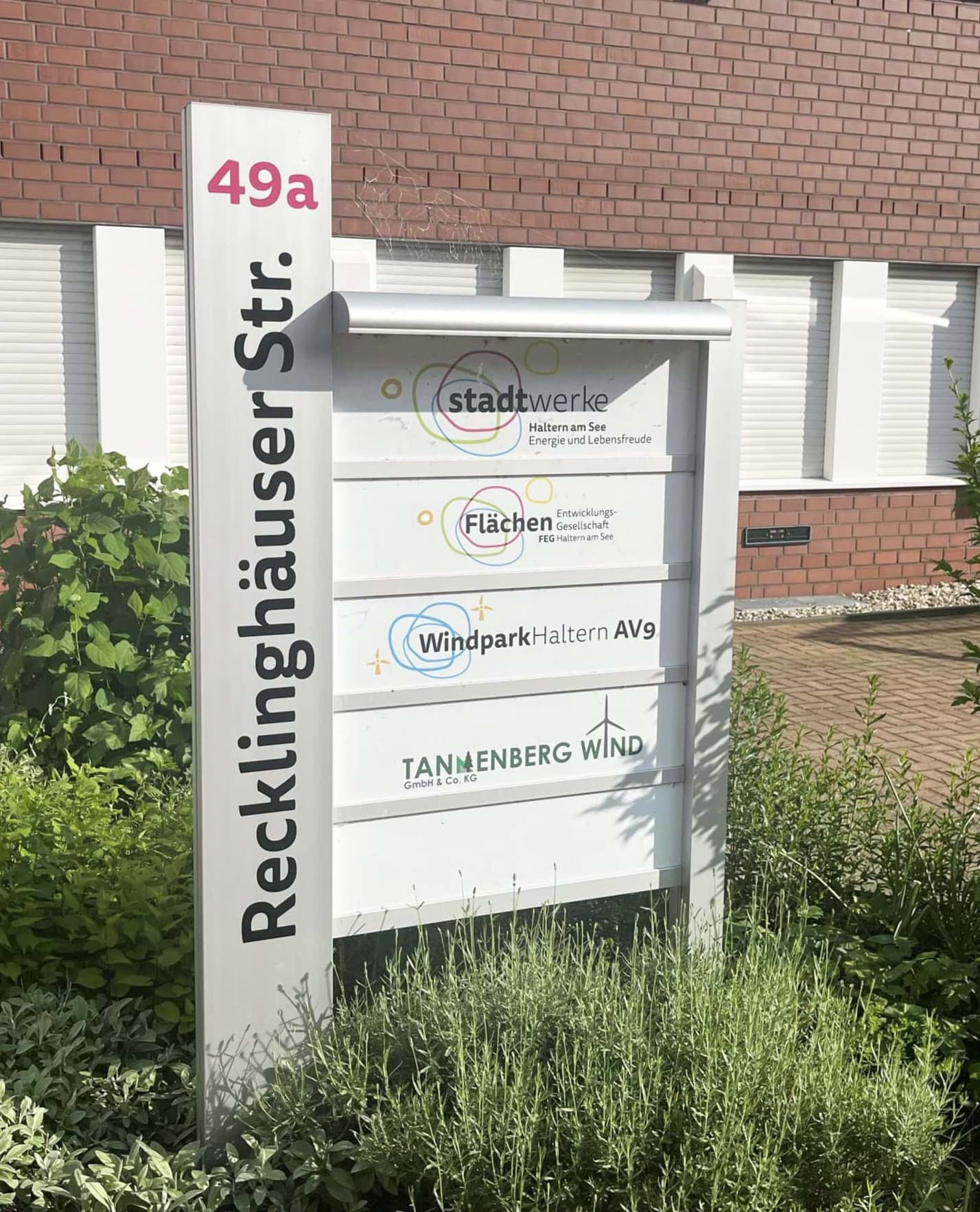 Beleuchtetes Firmenschild mit Infostele und mehreren Unternehmen